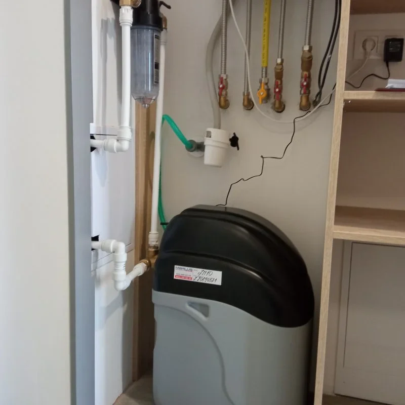 Zmäkčovač vody nainštalovaný v byte s potrubím, filtrami a rozvodmi vody.